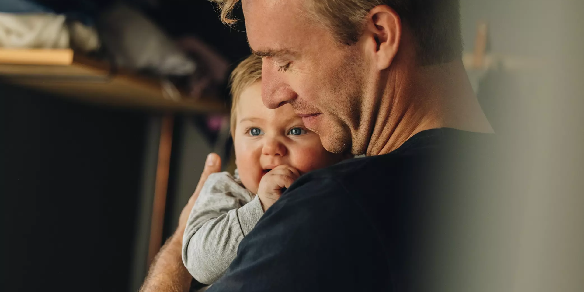 Vader houdt liefdevol zijn baby vast in een warme omhelzing.