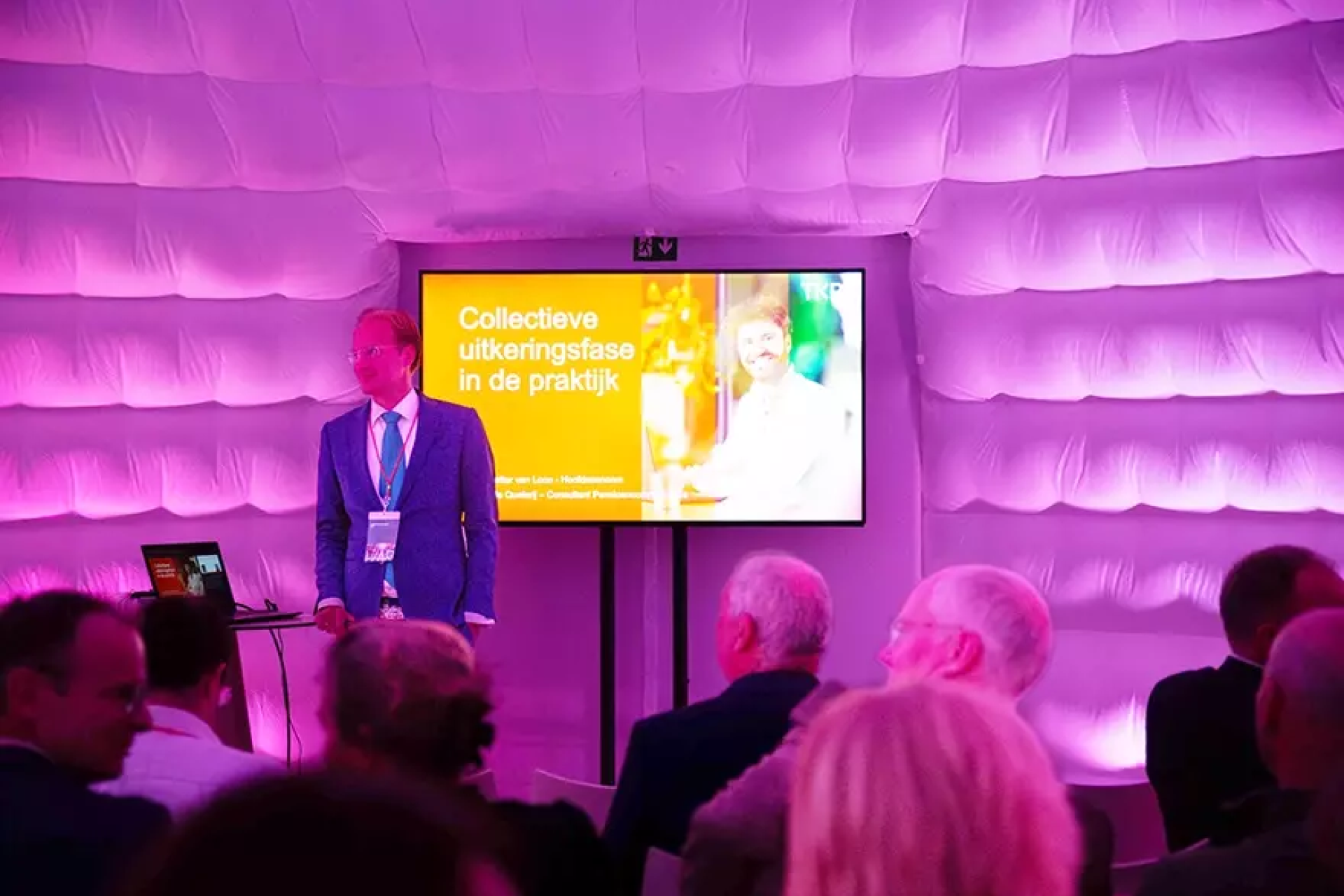 Man geeft presentatie in verlichte ruimte.