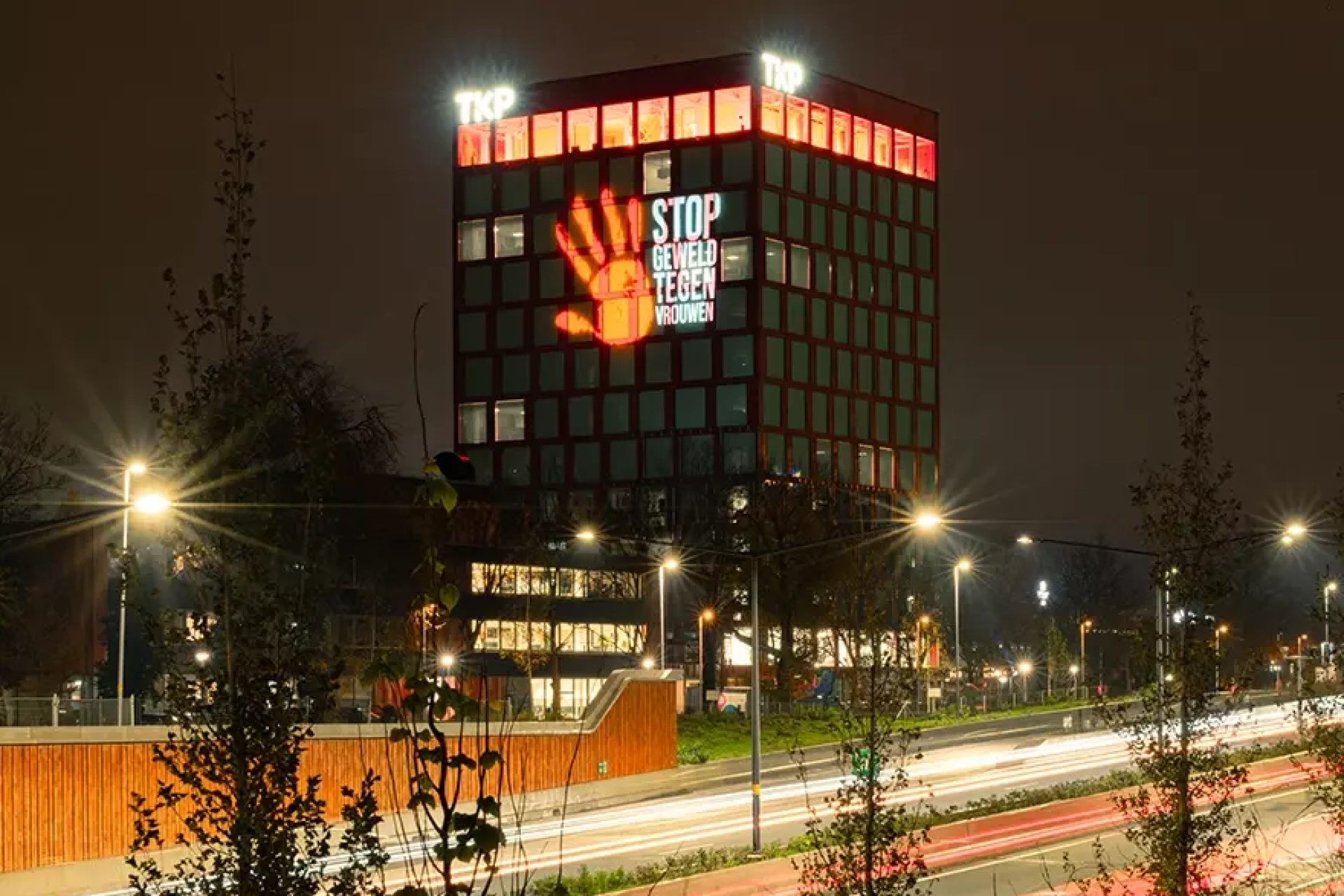Gebouw met lichtprojectie 'Stop geweld tegen vrouwen' bij nacht.
