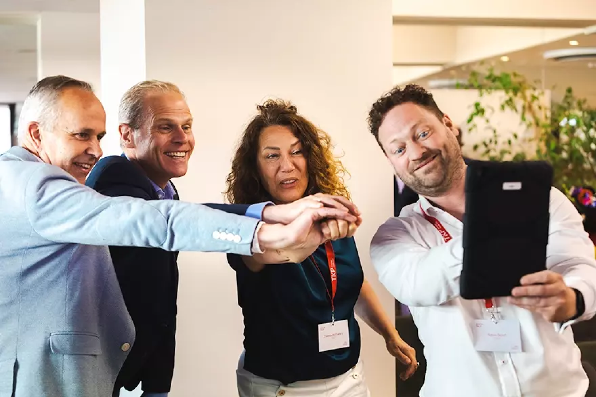Groep mensen die samen een selfie maken tijdens een bijeenkomst.